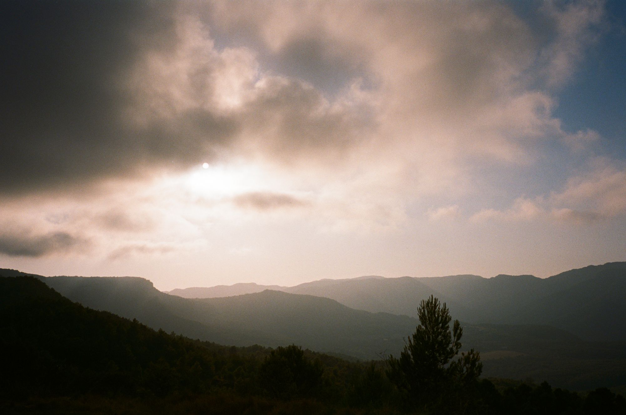 Moody mountain landscape, sun breaking through clouds